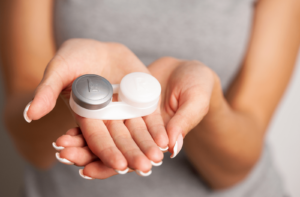 A woman holding out her palms with a contact lens case in her hands