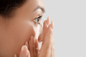 A woman inserting a contact lens into her eye.